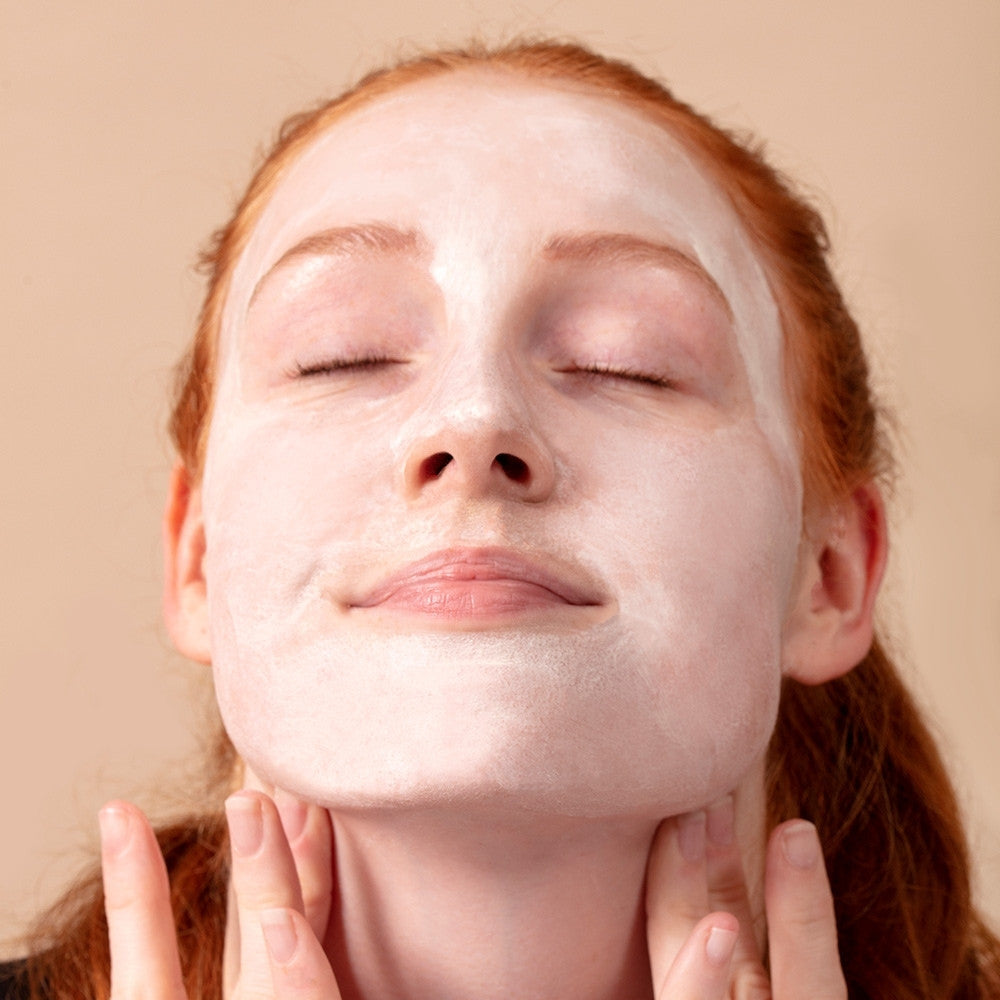 Model applying the Detoxifying Clay Masque. Skin is left clear, calm & soft. Suitable for sensitive skin.