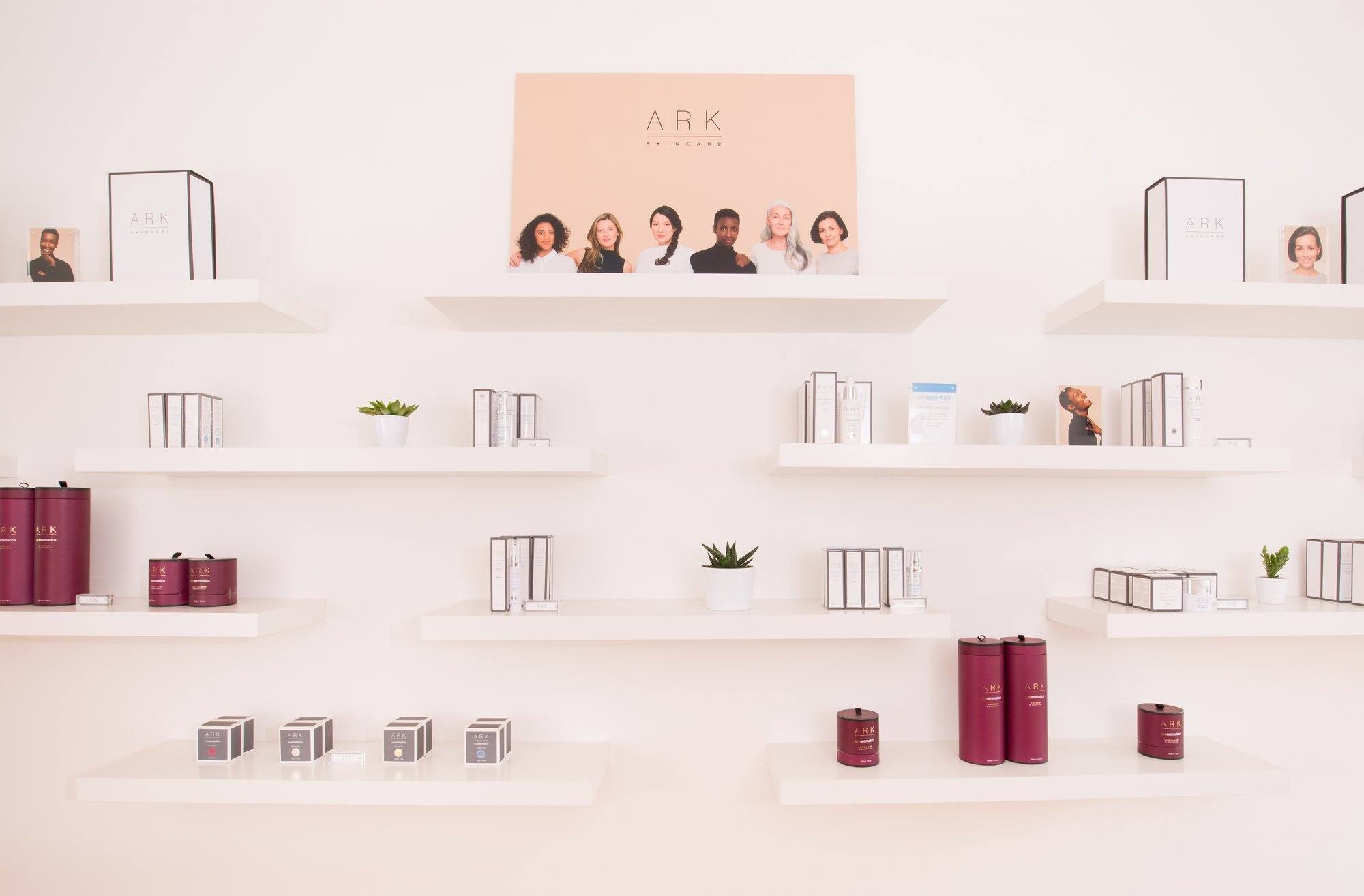 Shelves topped with ARK Skincare's various products, with an image of ARK Skincare models on the top shelf