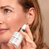 Model with Anti-redness serum, shows her bright, even complexion. Calms skin redness. Suitable for those with rosacea.