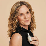 Model in their 50s uses ARKs Firming Serum on their neck and forehead, to lift & firm skin.