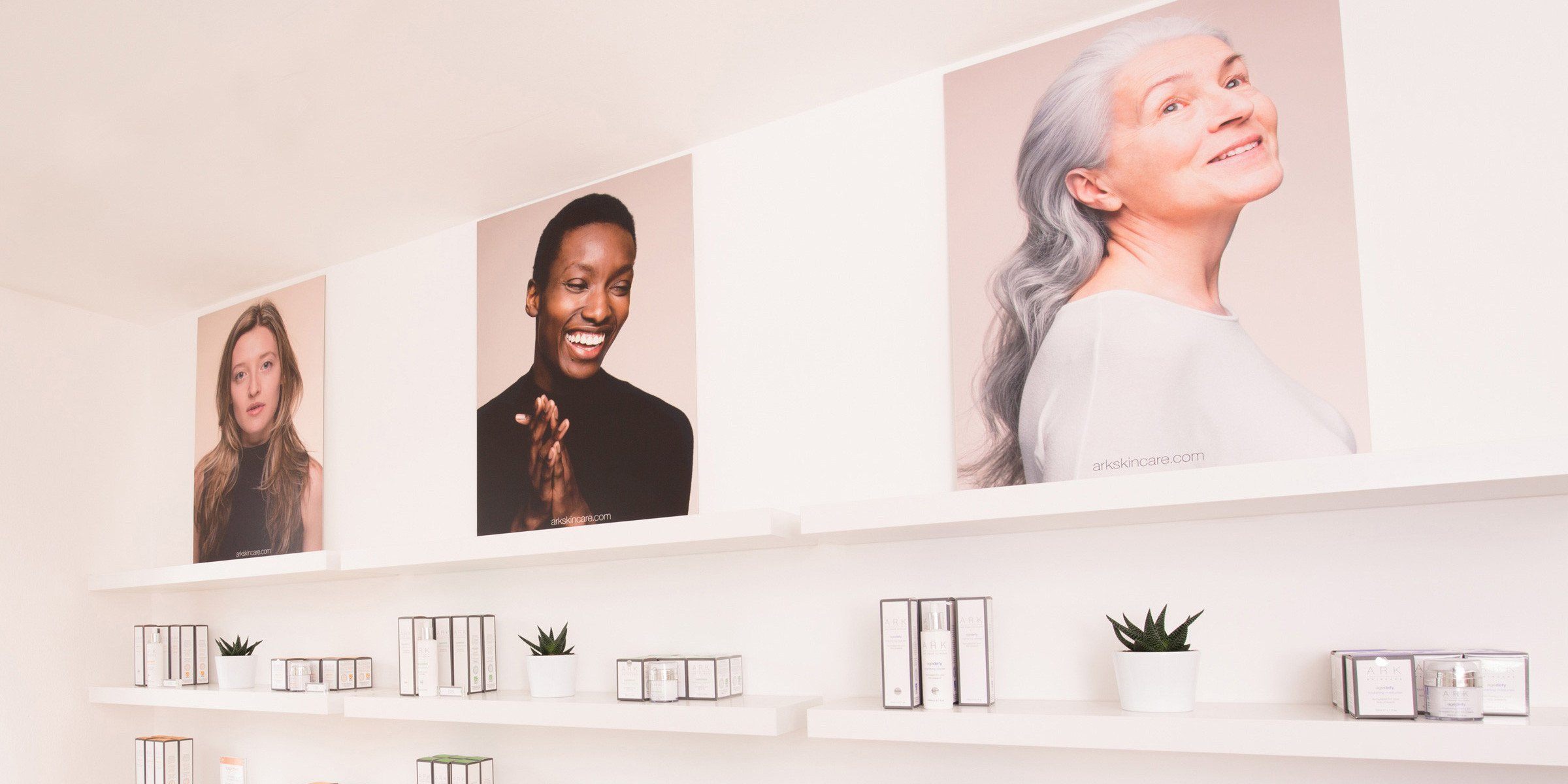 Large portraits of ARK Skincare's models and brand ambassadors lined up on the shelves inside the ARK Skincare Boutique